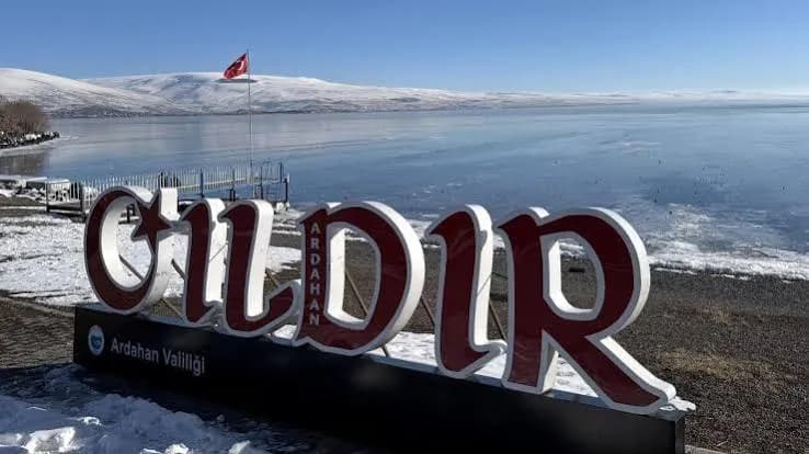 Karlı göl kıyısındaki büyük Çıldır yazısı